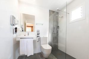 帕格拉海王星旅馆的浴室配有卫生间、盥洗盆和淋浴。