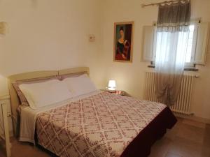奥斯图尼乔万纳罗拉温室住宿加早餐旅馆的一间卧室配有一张带毯子的床和窗户