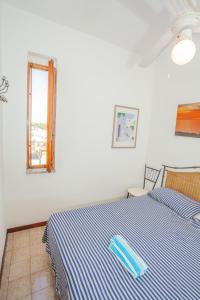 Baia VerdeSeaBreeze Baia Verde的卧室配有蓝色和白色的床,设有窗户