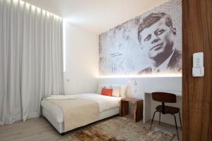 里斯本The ICONS Lisbon Central Hotel的白色卧室配有床和椅子