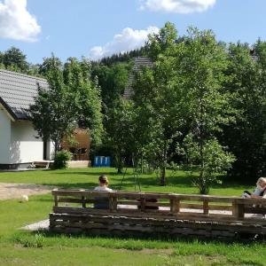 卡尔帕奇Domek Bobrowe Zacisze w Górach Sokolich的坐在公园长凳上的女人