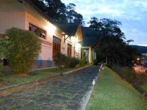 多明戈斯马丁斯Pousada Pouso do Barão的房屋前有鹅卵石街道的房子