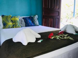 托尔图格罗All Rankins Eco-Lodge的一张带两条毛巾和鲜花的床