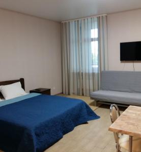 哈尔科夫Apart Hotel Smart Studio的一间卧室配有蓝色的床和沙发