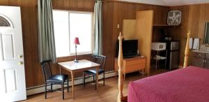 Lake CityAlpine Moose Lodge的一间卧室配有一张床、一张书桌和一台电视