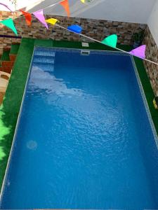 格拉纳达Casa al-andalus的一座大型蓝色游泳池,上面有五颜六色的旗帜