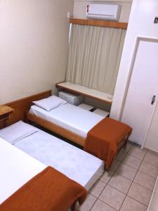 戈亚尼亚Hotel Serra das Águas的小房间设有两张床和窗户