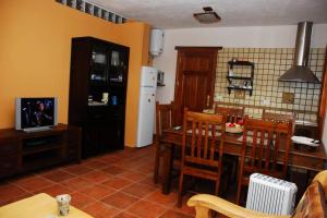 Las RosasCasa Rural La Casa de La Lima的厨房配有桌椅和电视。