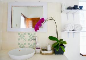 姆杜克阿约塔玛花园别墅的浴室设有水槽,柜台上有一朵花