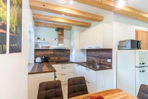 博希尼Apartmaji MM的厨房配有白色橱柜和桌椅