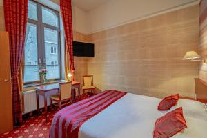 杜柏Hotel des Comtes Durbuy的配有一张床、一张书桌和一扇窗户的酒店客房