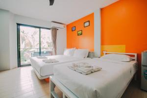 涛岛好梦酒店（坤英楼）的橙色墙壁客房的两张床