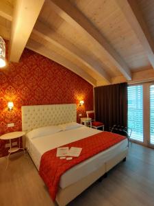 维罗纳新歌剧旅馆的一间卧室设有一张红色墙壁的大床
