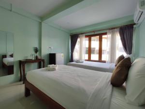 南邦Ban Mae Boonthong的卧室配有一张大白色床和窗户