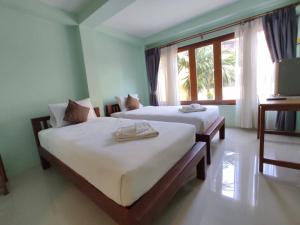 南邦Ban Mae Boonthong的一间卧室设有两张床和窗户。