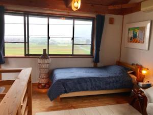 富山ヨーコのお宿 わくわく的一间卧室设有一张床和一个大窗户