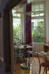根特爱玛别墅住宿加早餐旅馆的一间带桌椅和窗户的用餐室