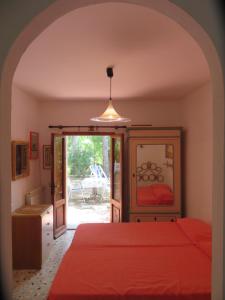 坎普码头I GECHI - MARINA DI CAMPO的一间卧室配有红色的床和镜子