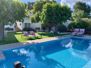 Pla del Panadés葡萄酒&烹饪派内迪斯住宿加早餐旅馆的一个带椅子的庭院和房子的游泳池