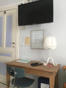 Zottegem精美鲜花住宿加早餐酒店的墙上一张桌子,上面有台灯和显示器