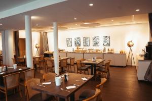 森登费伊尔勒酒店的一间带木桌椅的餐厅和一间酒吧