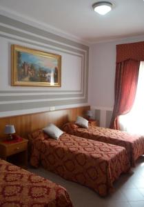 波梅齐亚法西奥尼酒店的酒店客房设有两张床,墙上挂有绘画作品
