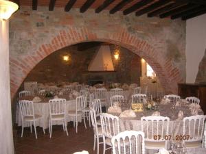 佩尔吉内-瓦尔达诺Agriturismo Il Palazzo的一间设有白色桌椅的房间和砖墙