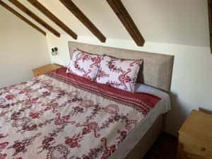 采蒂涅Lovcen Holiday Home的一张铺有红白色床单和枕头的床