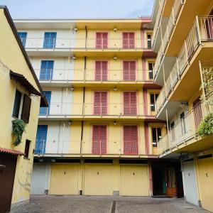 亚历山德里亚科索蒙费拉托住宅酒店的黄色的建筑,设有红色的门和阳台