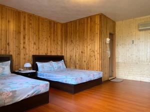 古坑华亿民宿的一间卧室设有两张床和木镶板墙
