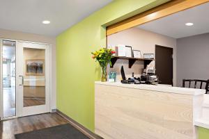 斯帕克斯WoodSpring Suites Reno Sparks的一个带绿色墙壁和鲜花柜台的办公室