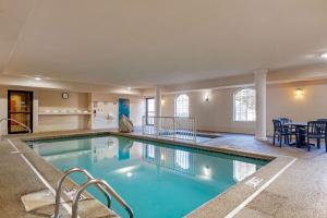 史蒂文斯维尔斯蒂文斯圣乔瑟夫康福特套房酒店的大楼内一个蓝色的大型游泳池