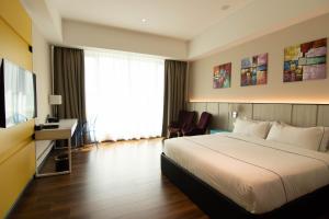 斯里巴加湾市Higher Hotel的酒店客房配有一张床、一张书桌和一台电视。