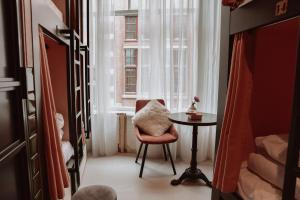 阿姆斯特丹Durty Nelly's Inn的窗户房间里一张椅子和一张桌子