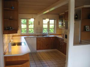 斯文堡Thurø Kro B&B的厨房配有木制橱柜和白色的电器