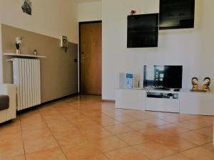 佩斯基耶拉德加达KARINA'S home的带电视的客厅和瓷砖地板。