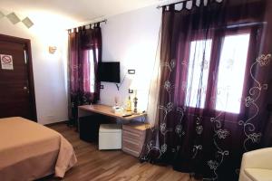 佩斯基奇Sunset Bed & Breakfast的一间卧室配有紫色窗帘、一张书桌和一个窗户。
