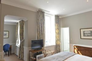 枫丹白露德隆德里斯酒店的一间卧室设有一张床、一台电视和一个窗口。