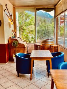 若西耶Hôtel Bel'Air的餐厅设有蓝色的椅子、桌子和窗户