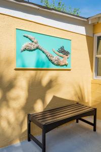 富丽海滩Folly Vacation Laid Back Casual Beach Bungalow 209-B的坐在墙上的长凳上,画着一幅画