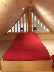 普卢阿尔内APPT T2 PROCHE PLAGE的阁楼上一间卧室配有红色的床