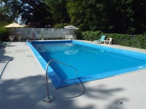 霍尔德内斯Yankee Trail Motel的庭院里一个带蓝色滑梯的游泳池