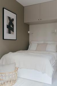 弗罗茨瓦夫APARTAMENT Marina Port的卧室配有一张大白色床和篮子