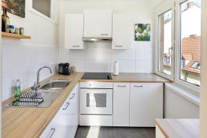 格拉茨Helle und gemütliche Wohnung in zentraler Lage的厨房配有白色橱柜、水槽和窗户。