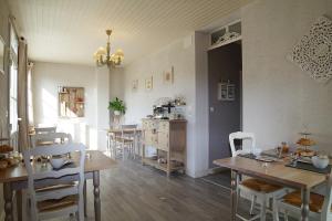 Graye-sur-MerLes 4 saisons的一间带桌椅的用餐室和一间厨房