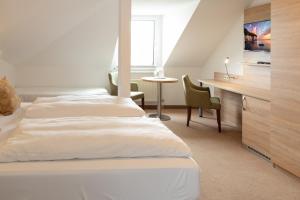 NeuensienFerienpension Seeblick的酒店客房设有两张床和一张桌子。