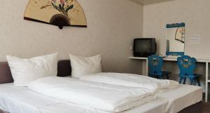 罗滕堡China Restaurant Hotel Lotus的一间卧室配有一张带白色床单和蓝色椅子的床