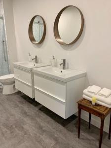 莱维斯Appartements Gite Kezako的白色的浴室设有两个盥洗盆和镜子