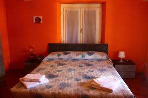 贝拉诺德拉戈旅馆的一间卧室拥有橙色的墙壁,床上配有2条毛巾