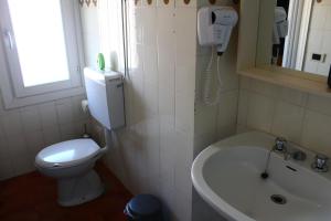 贝拉诺德拉戈旅馆的一间带卫生间、水槽和电话的浴室